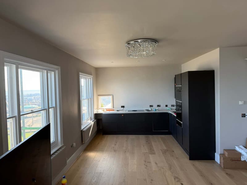 Bright open-plan kitchen and living room with oak floor and sash windows