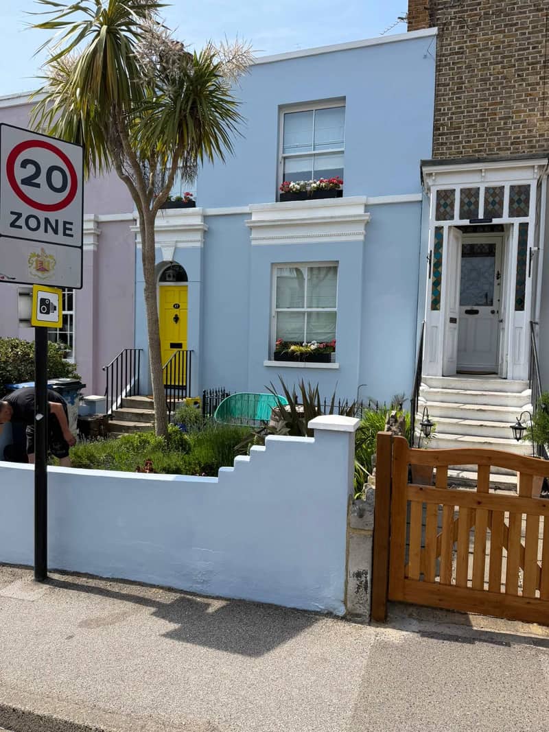 Painted front garden wall and terrace facade seen from the street